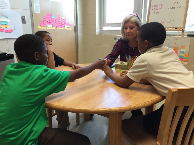 Getting their hands on concepts: Diane Wehby's students learn literacy with words and weight measurements (an eraser = "ounces").