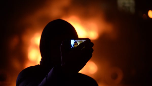 https://archive.wbhm.org/wp-content/uploads/2019/01/Masked_protester_taking_jis_self_portrait_against_background_of_barricades_on_fire._Dynamivska_str._Euromaidan_Protests._Events_of_Jan_19_2014-600x338.jpg
