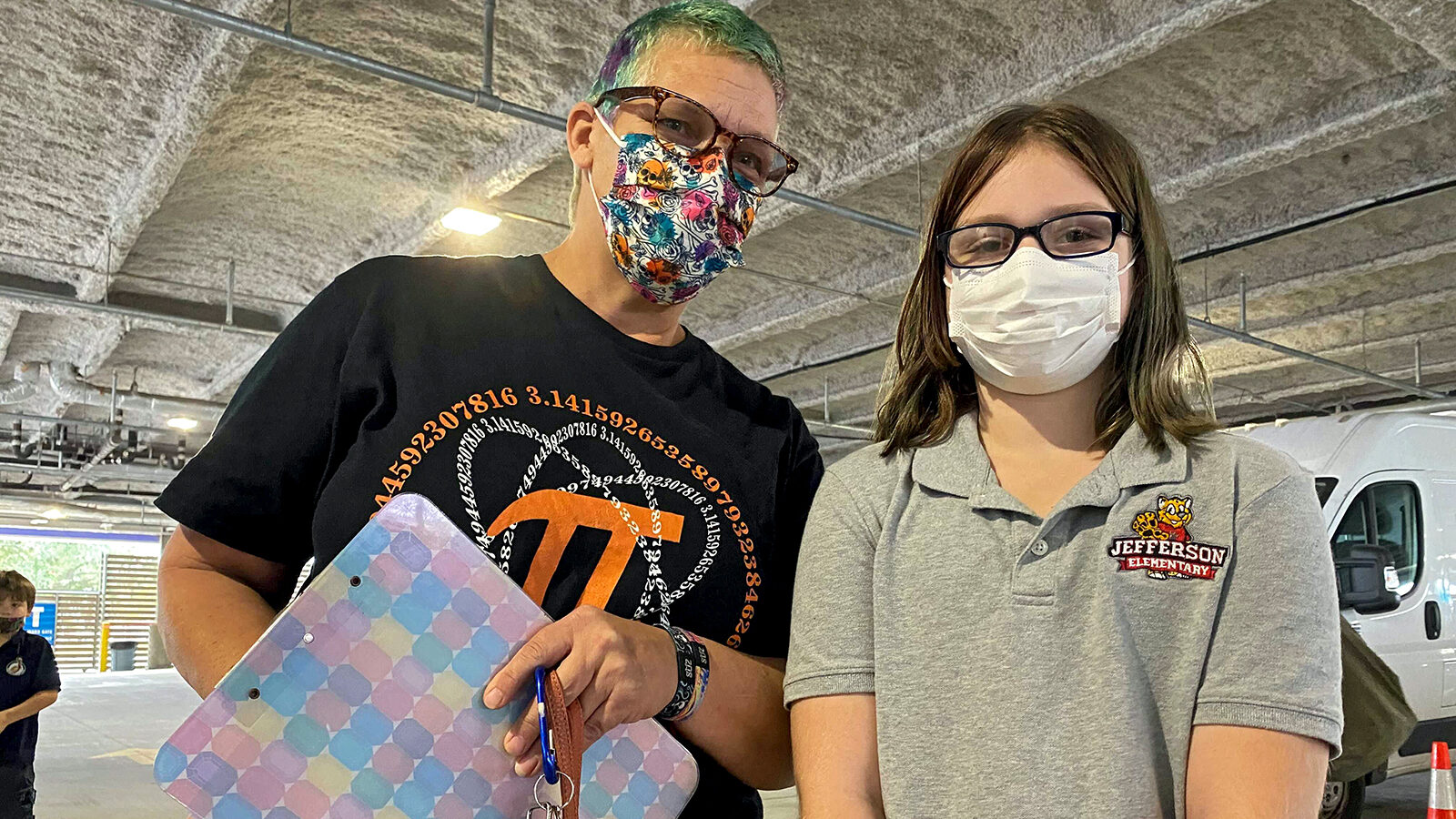 Kate Foquet (left) stands next her her daughter Anya, 9, before Anya arrives at New Orleans' Crescent Care to receive a COVID-19 vaccine.