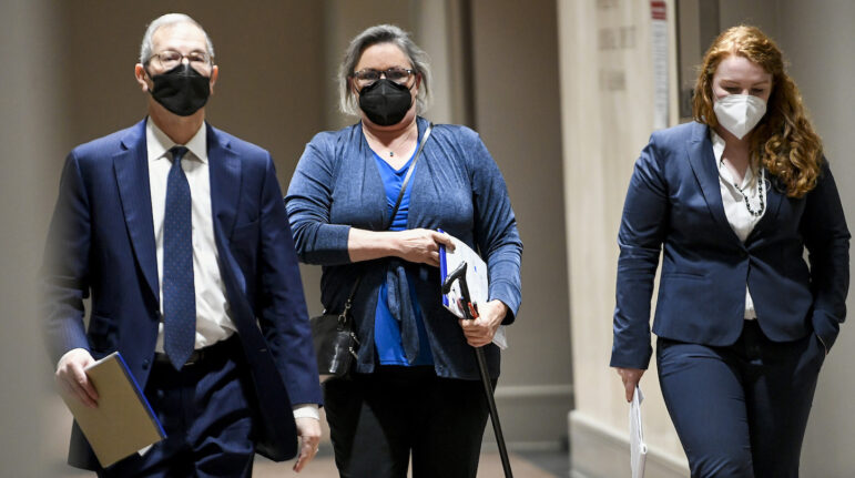 Leigh Corfman, center, who accused former Alabama Chief Justice Roy Moore of sexual assault, walks into the courtroom in the Montgomery County Courthouse in Montgomery, Ala., on Monday, Jan. 24, 2022, during jury selection, as the trial for Corfman and Moore's defamation lawsuits against each other begins. (Mickey Welsh/The Montgomery Advertiser via AP)