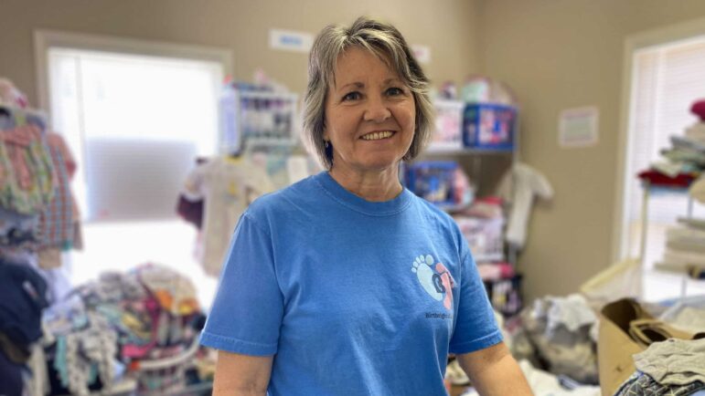 Monica Walton, director of Birthright of Jackson, a pregnancy resource center in Mississippi, on June 13, 2022, in front of a stack of donated maternity and infant clothes.