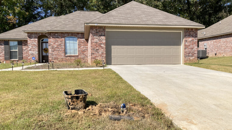 A resident of one of Byram, Mississippi’s newer subdivisions experiences issues with her water meter, leaving her with a muddy yard, Oct. 7, 2022.