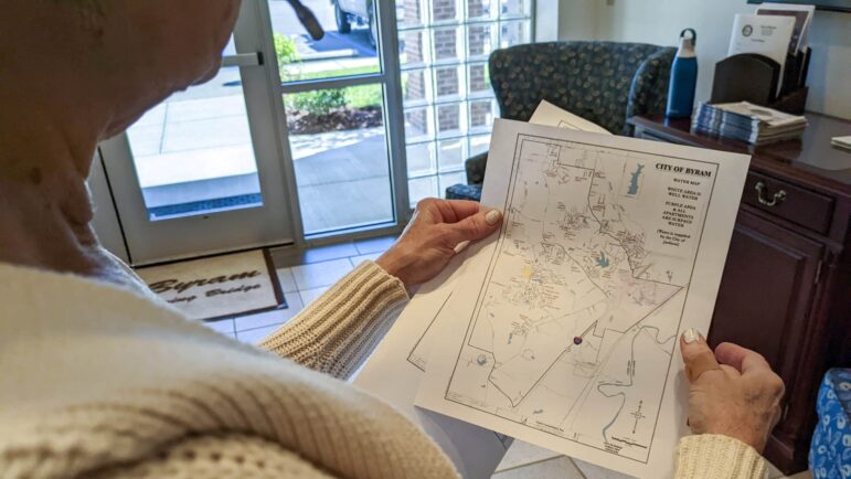 Shari Collins, an assistant and a receptionist to the Byram mayor’s office, holds a map highlighting the parts of Byram that use surface water, which comes from Jackson’s treatment plants, and well water, Oct. 6, 2022.
