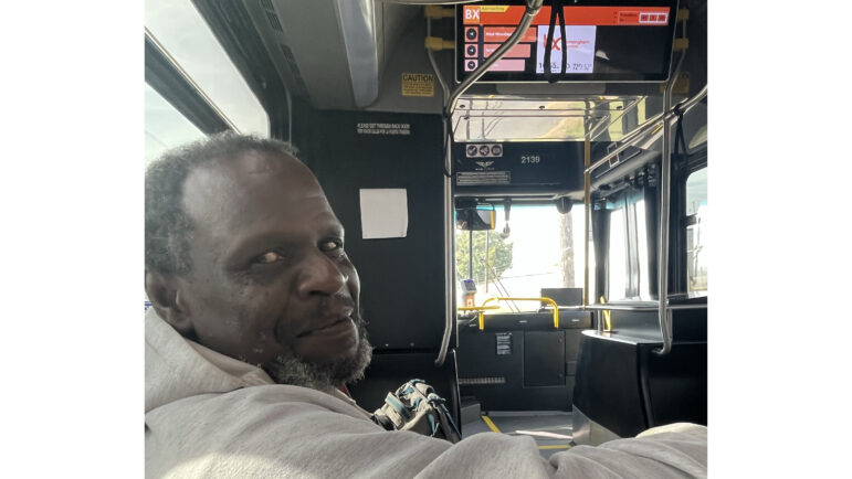 William Britton, who is without a home, sits inside a Birmingham Xpress bus.