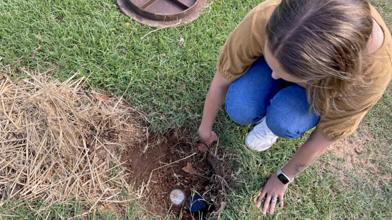 Claire Ahalt inspects her water meter outside of her home in Birmingham, Alabama, Sept. 28, 2023.