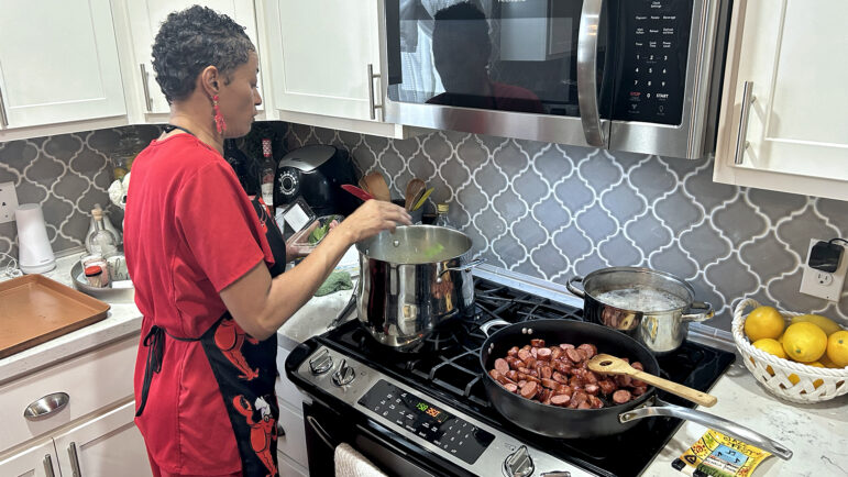 Bunny Young adds the holy trinity — celery, onion and green bell pepper — and browned andouille sausage to her pot of gumbo on Dec. 8, 2023.