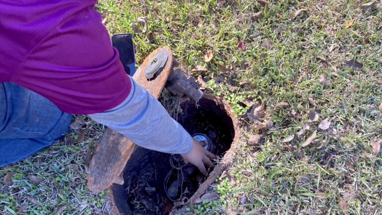 James Henley uncovers the water meter for the home he uses as his law office in Jackson, Mississippi, on Dec. 5, 2023.