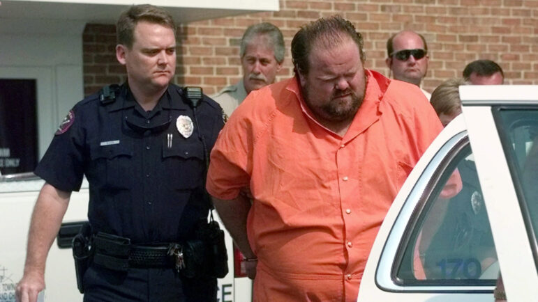 In this file photo, Officials escort Alan Eugene Miller away from the Pelham City Jail in Alabama, Aug. 5, 1999.