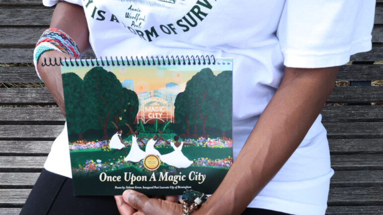 A female poet holds her chapbook in her hands.