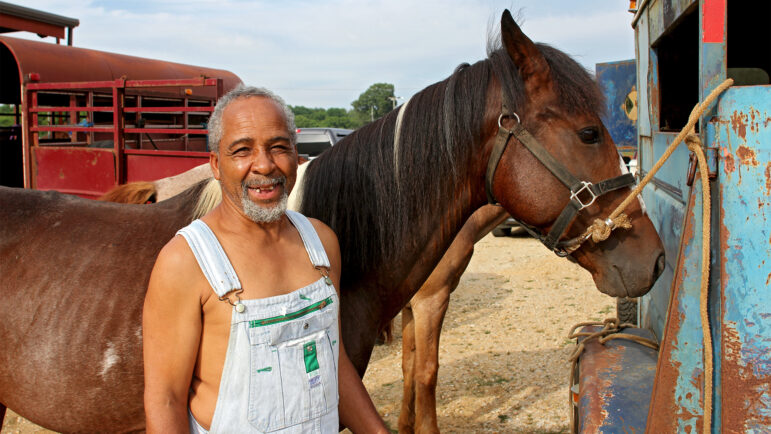 Barry Golden stands beside his horses Spear, 6, and Prince, 25, before the Pontotoc Juneteenth Horse Show on June 19, 2024.