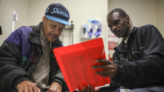 Community health worker Ron Sanders, right, helps a patient at San Francisco’s Southeast Family Health Center, part of the Transitions Clinic Network that assists former inmates navigate health care after release.