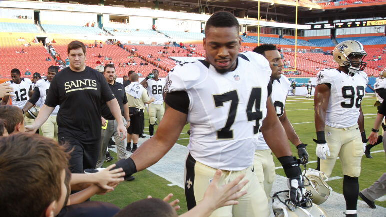 In this file photo, New Orleans Saints defensive end Glenn Foster Jr. (74) greets fans after practice before an NFL preseason football game against the Miami Dolphins, Thursday, Aug. 29, 2013, in Miami Gardens, Fla.