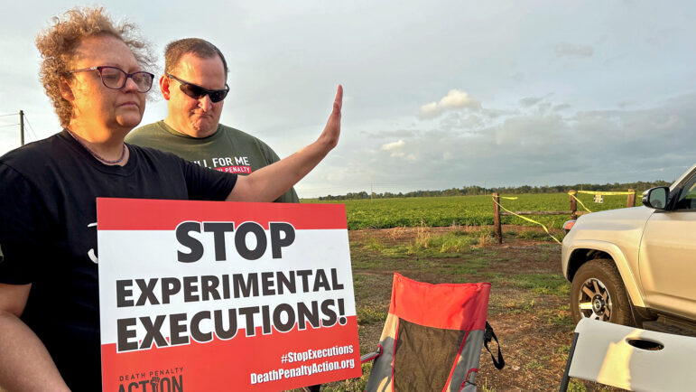 A death penalty opponent appears to raise a hand in contemplation at a protest of the gas execution of Alan Miller in Atmore, Alabama, on Sept. 26, 2024.