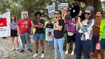 Participants at a rally and march hold up signs protesting President Donald Trump's appearance at Super Bowl 59 in New Orleans on Sunday, Feb. 9. 2025.