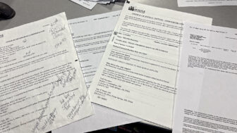 A stack of denial letters and correspondence from Molina Healthcare and Ochsner Health lie on a table in the Malosh family store in Ocean Springs, Mississippi, on Dec. 20, 2024.