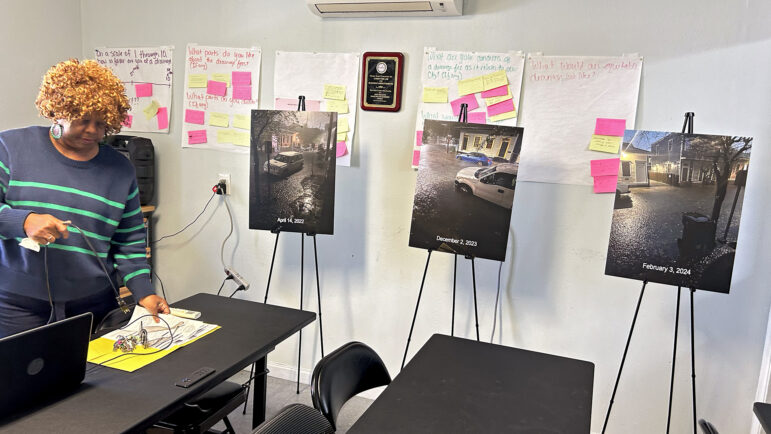 Cheryl Austin stands next to photos of previous flooding events in New Orleans' Treme neighborhood on Thursday, March 6, 2025.