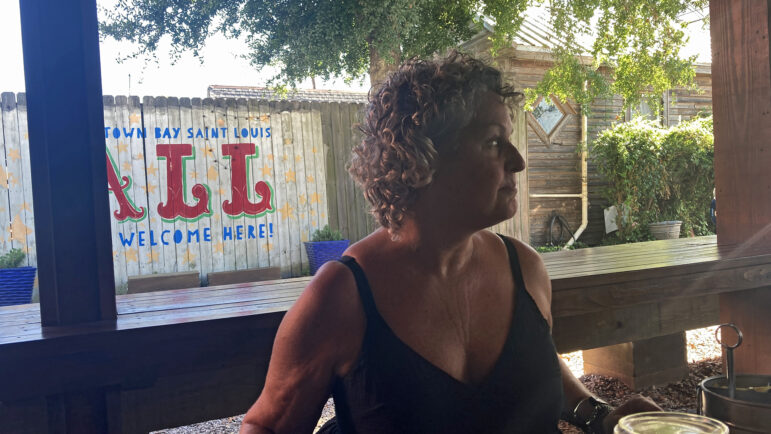 Alicein Schwabacher sits on the patio of the Mockingbird Cafe in Bay St. Louis, Mississippi, on Aug. 15, 2025.