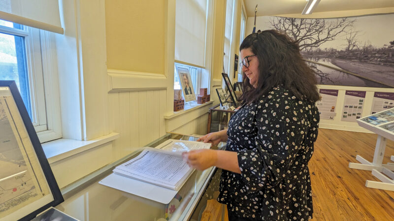 Linda Gieseler, whose letter to Santa is on display at the Ground Zero Hurricane Katrina Museum, flips through a binder of other letters.